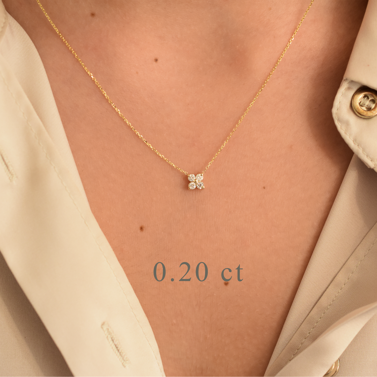 Gold necklace with a diamond pendant on a person's neck, labeled '0.20 ct'.