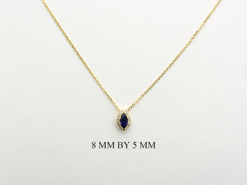  14K gold necklace featuring a marquise-cut sapphire center stone surrounded by a delicate diamond halo displayed on white background
