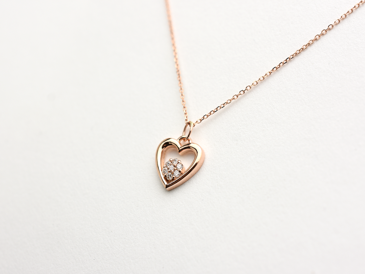 featuring a 14k gold heart necklace with a flower cluster motive 11 mm in dimension . the chain is a 14k sold gold cable link chain with a lobster lock 