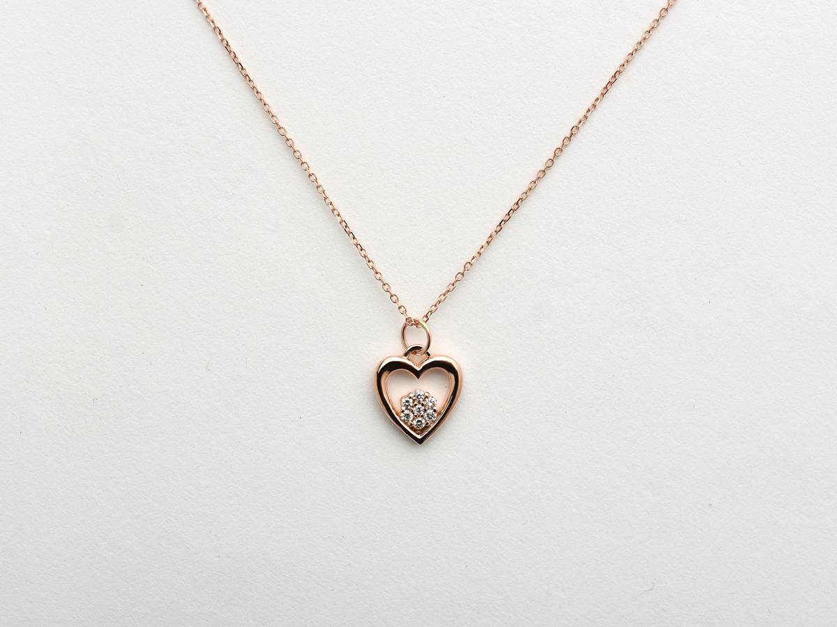 featuring a 14k gold heart necklace with a flower cluster motive 11 mm in dimension . the chain is a 14k sold gold cable link chain with a lobster lock 
