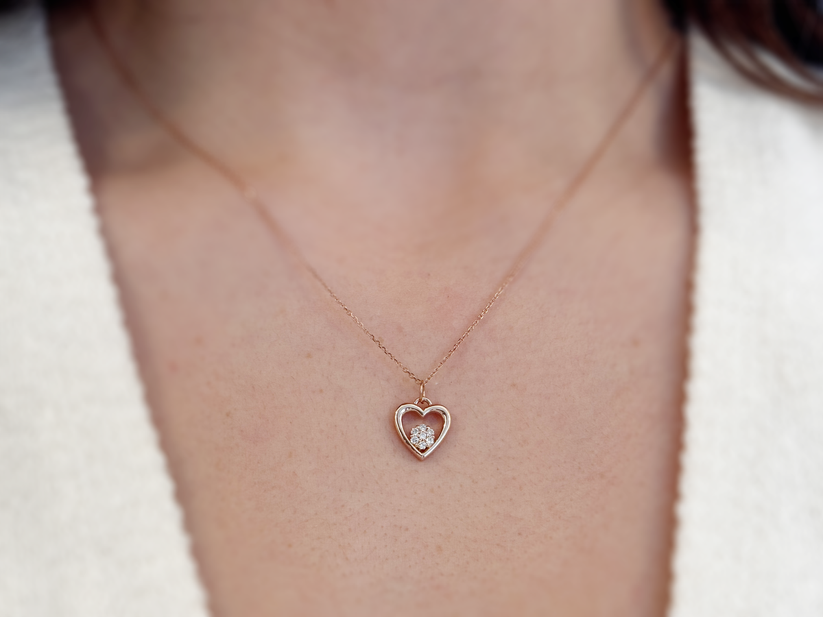featuring a 14k gold heart necklace with a flower cluster motive 11 mm in dimension . the chain is a 14k sold gold cable link chain with a lobster lock 