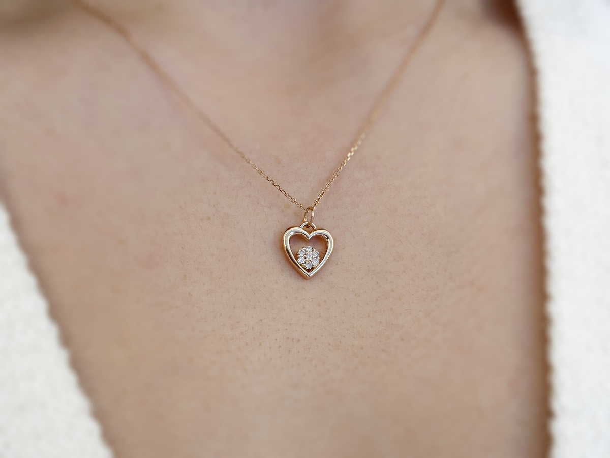 featuring a 14k gold heart necklace with a flower cluster motive 11 mm in dimension . the chain is a 14k sold gold cable link chain with a lobster lock 