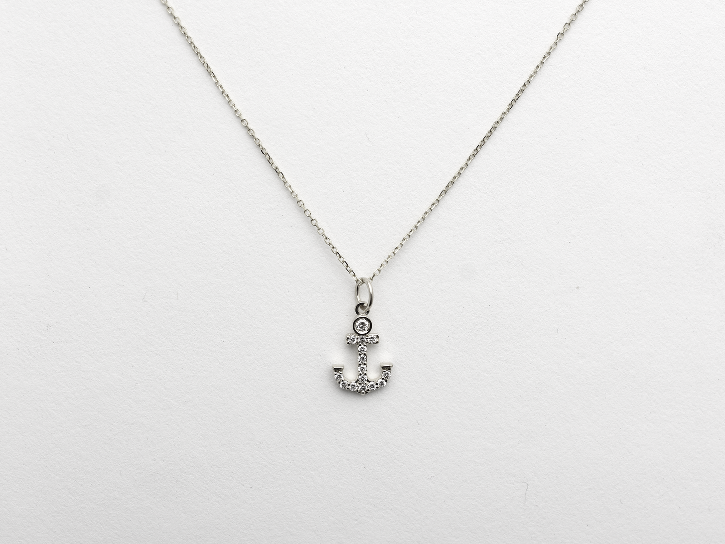 14k Gold and diamond Anchor necklace pendant with a 14k solid gold cable link chain, the diamonds are prong set and bezel set sliding on the chain displayed on a white background