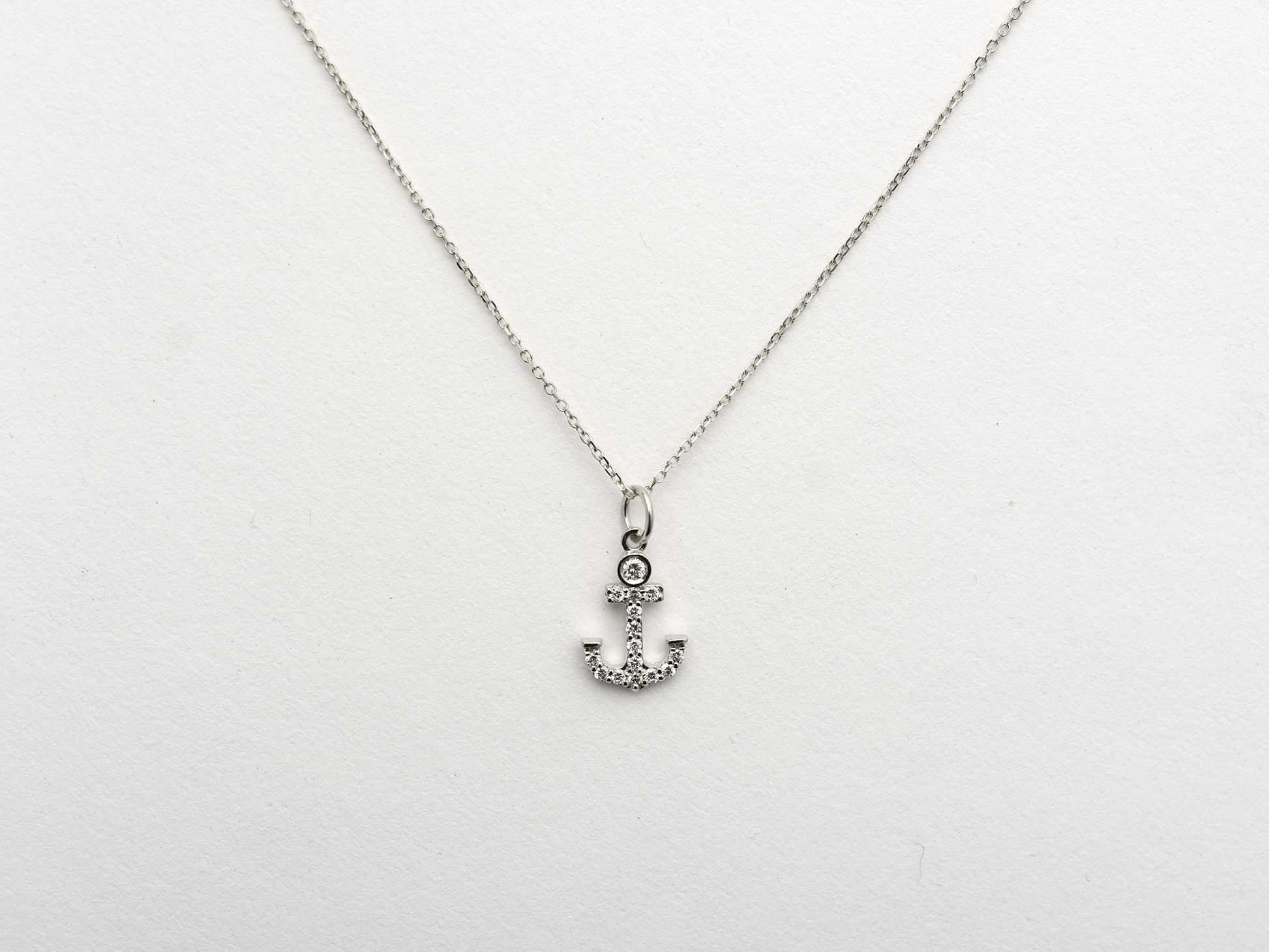14k Gold and diamond Anchor necklace pendant with a 14k solid gold cable link chain, the diamonds are prong set and bezel set sliding on the chain displayed on a white background