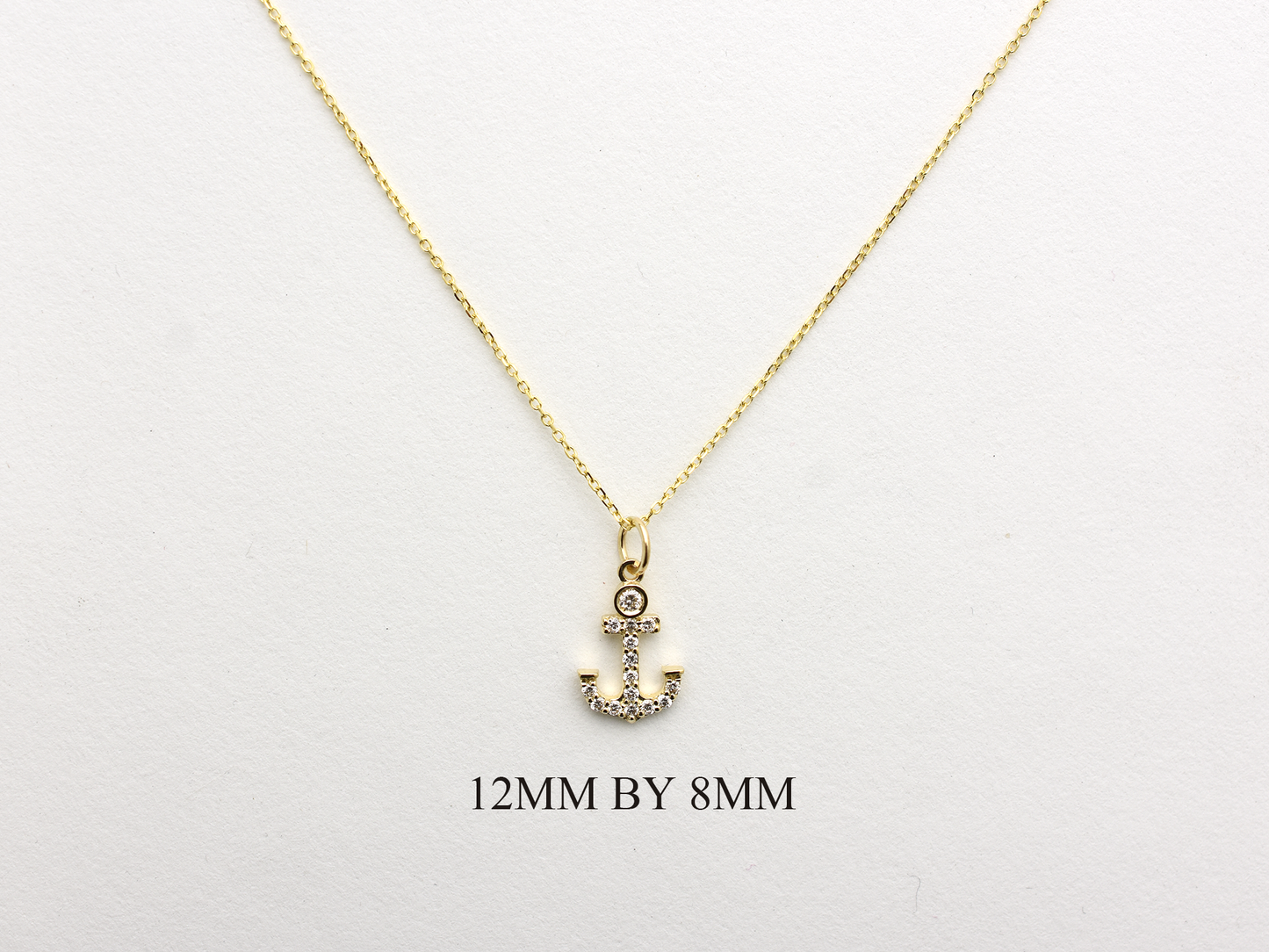 14k Gold and diamond Anchor necklace pendant with a 14k solid gold cable link chain, the diamonds are prong set and bezel set sliding on the chain displayed on a white background