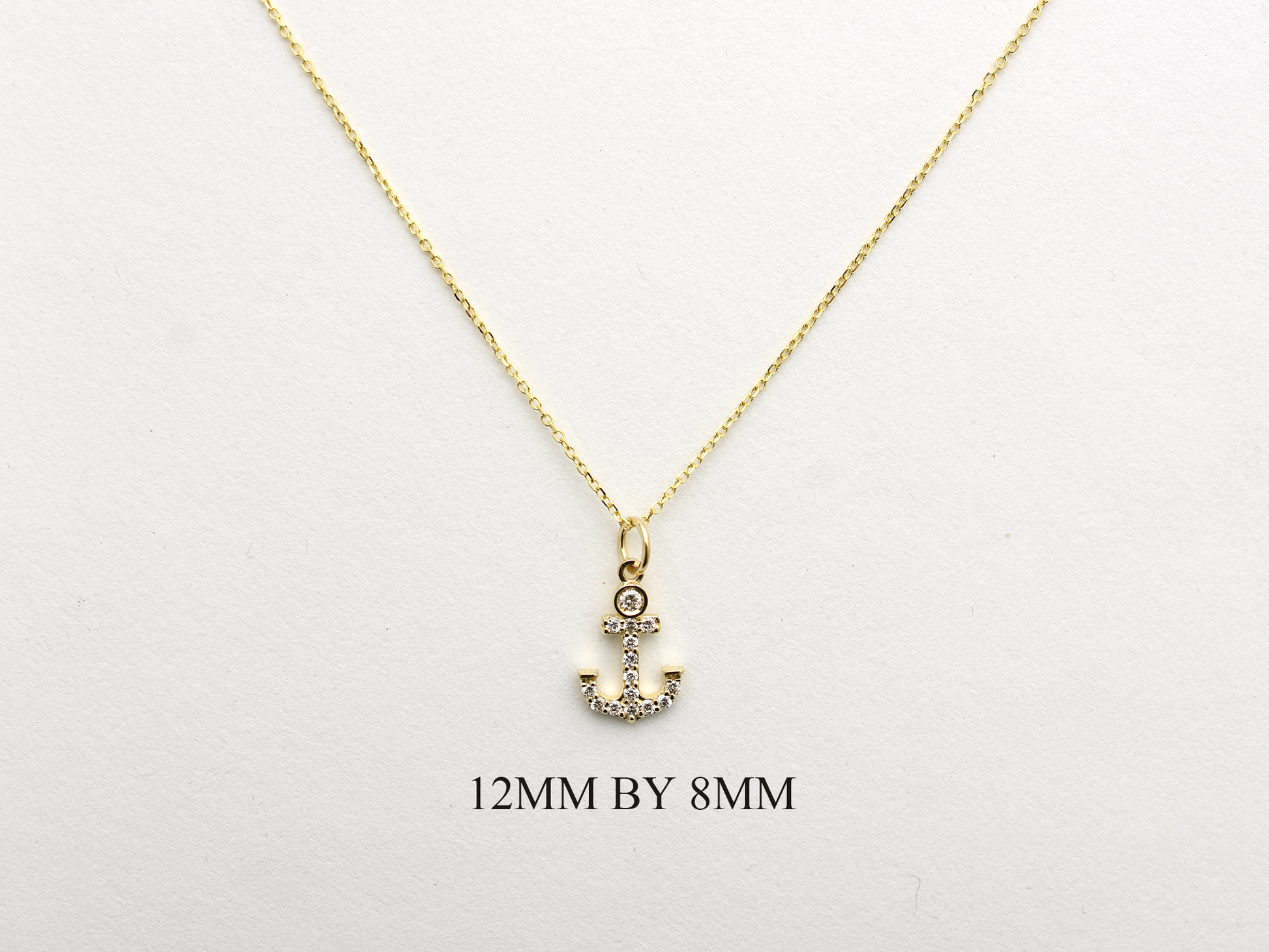14k Gold and diamond Anchor necklace pendant with a 14k solid gold cable link chain, the diamonds are prong set and bezel set sliding on the chain displayed on a white background