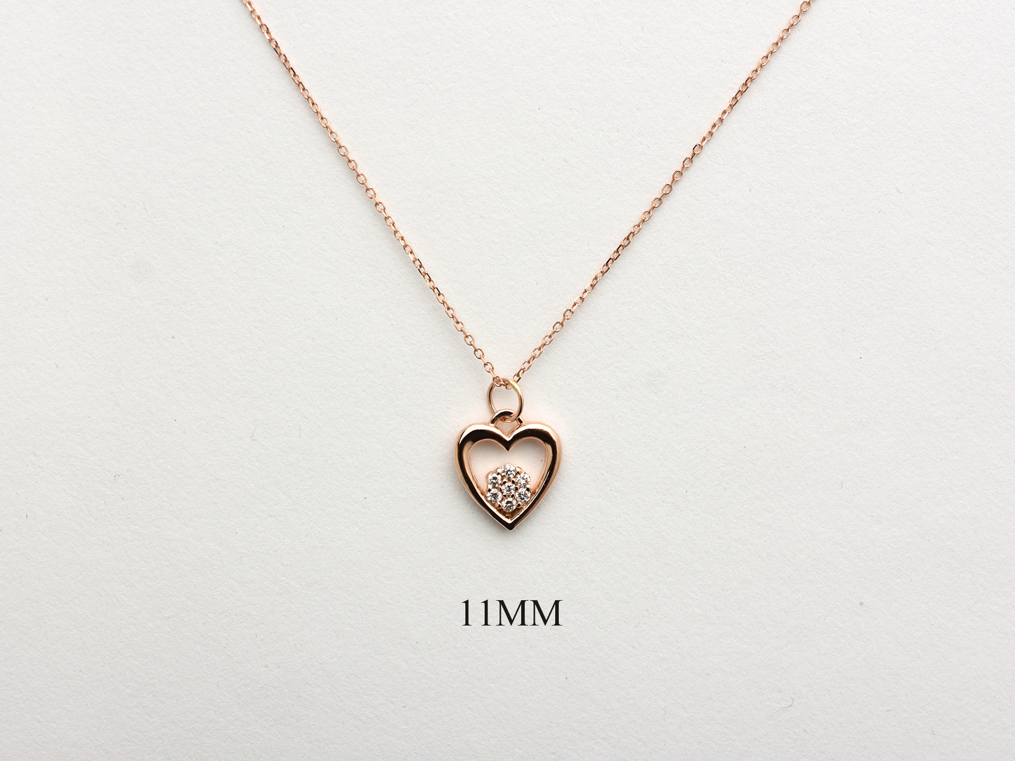 featuring a 14k gold heart necklace with a flower cluster motive 11 mm in dimension . the chain is a 14k sold gold cable link chain with a lobster lock 