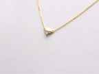  featuring a dainty three-stone diamond cluster pendant. The centerpiece consists of one slightly larger round brilliant cut stone flanked by two smaller stones in a minimalist prong setting on a fine gold cable chain with a lobster claw clasp