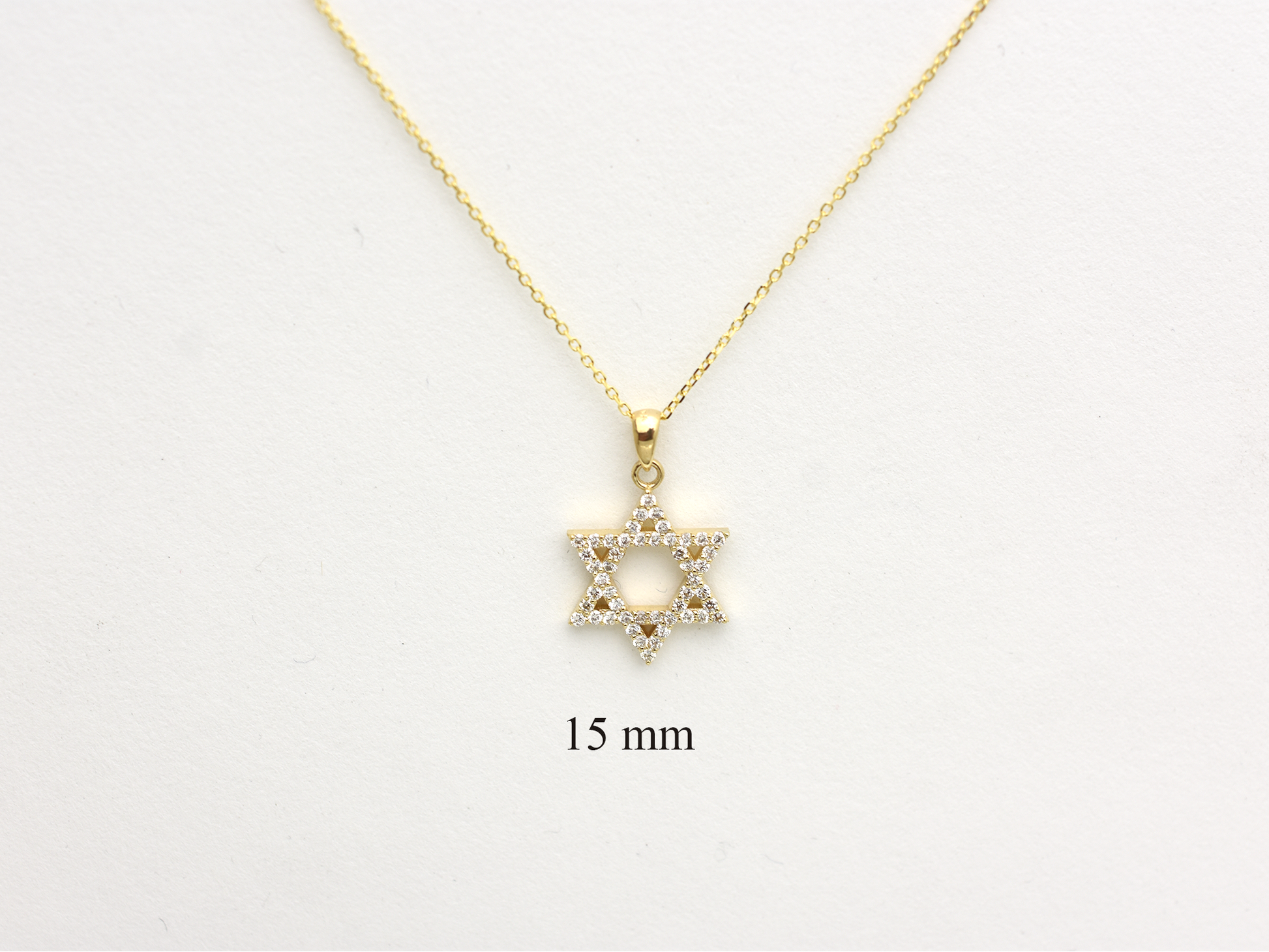 A gold-colored necklace with a Star of David pendant. The pendant is 15 mm in size and is encrusted with natural diamonds. The chain is delicate and hangs against a white background.
