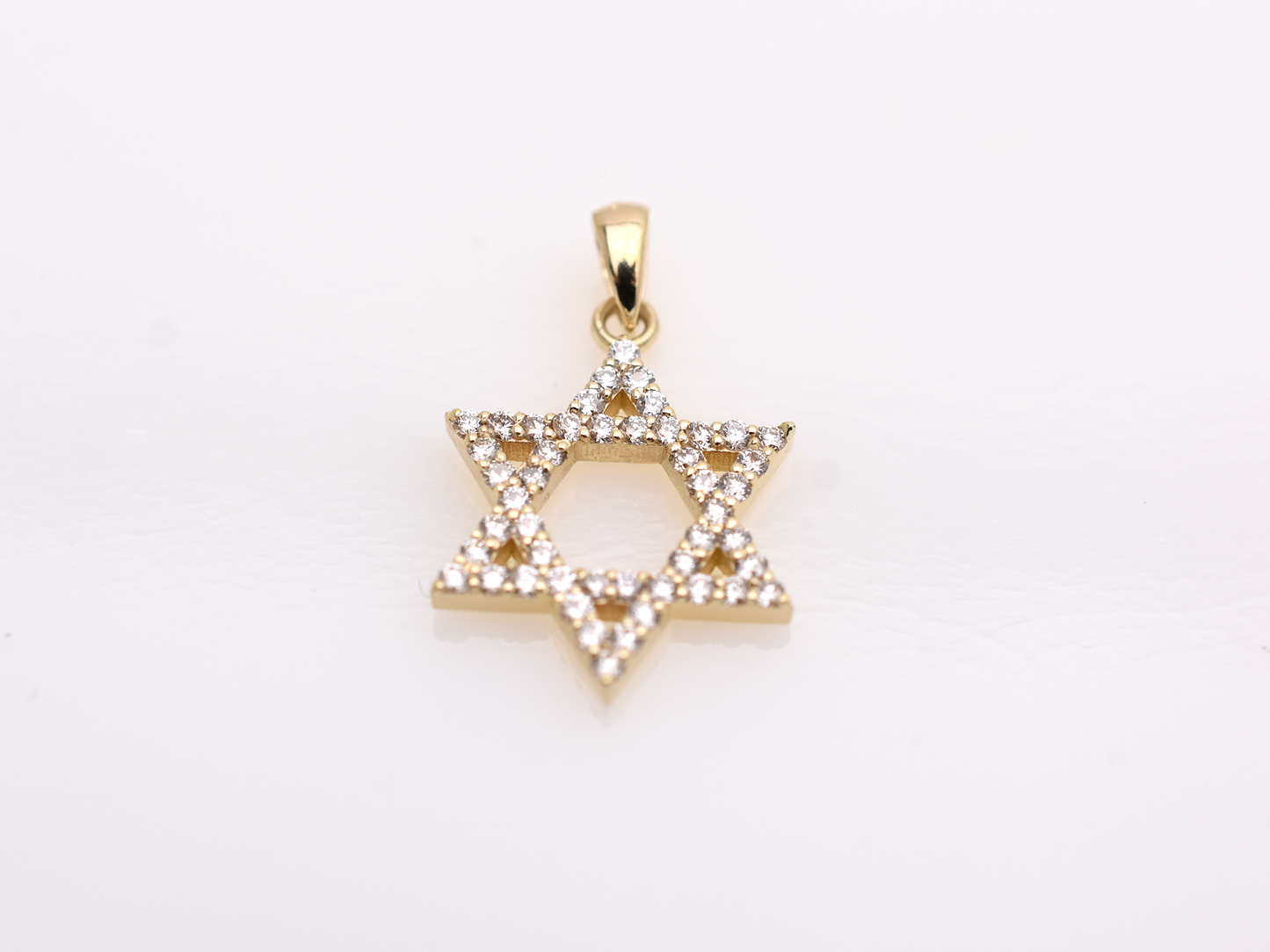 A gold-colored necklace with a Star of David pendant. The pendant is 15 mm in size and is encrusted with small, clear gemstones. The chain is delicate and hangs against a white background.