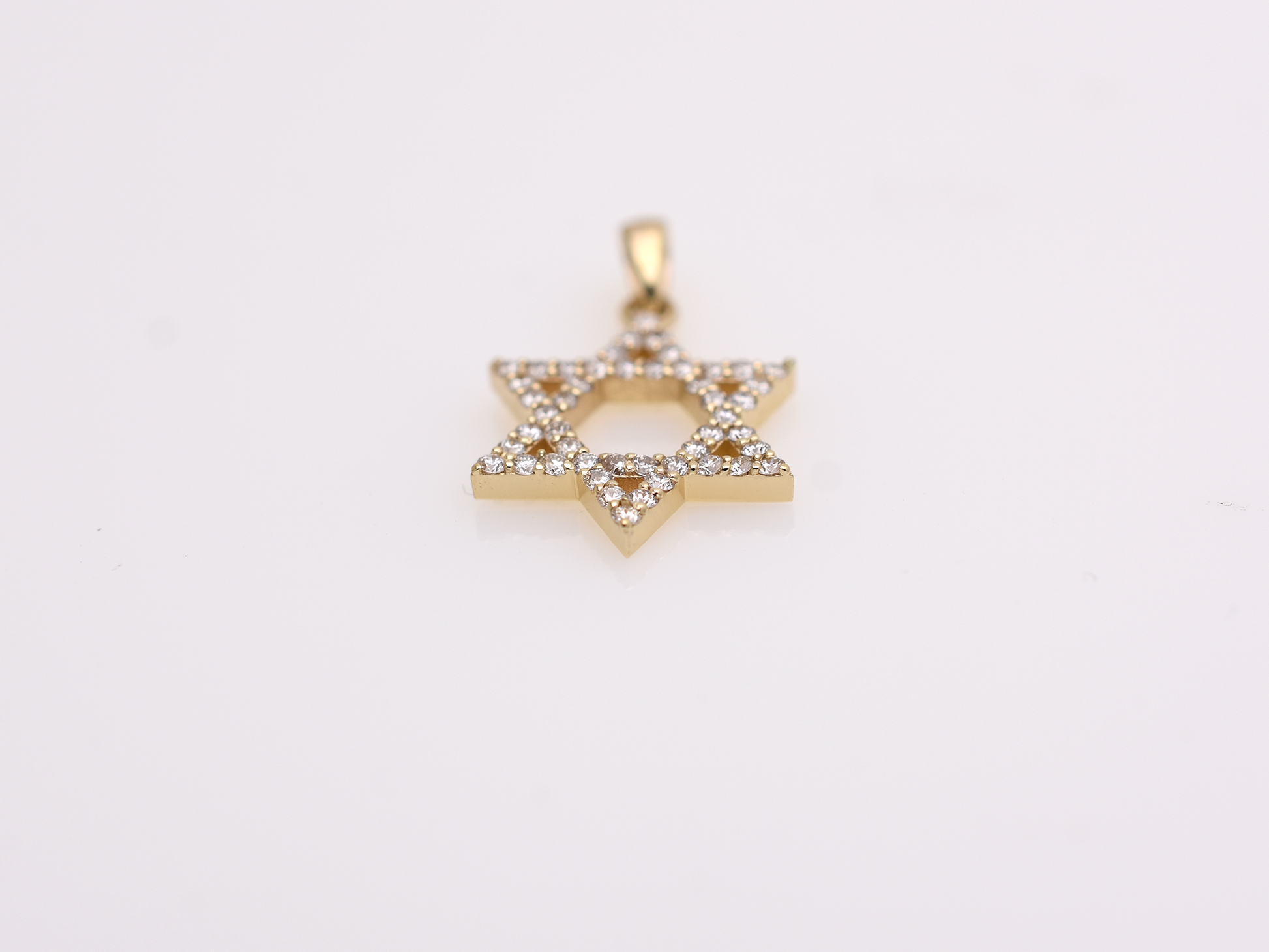 A gold-colored necklace with a Star of David pendant. The pendant is 15 mm in size and is encrusted with small, clear gemstones. The chain is delicate and hangs against a white background.