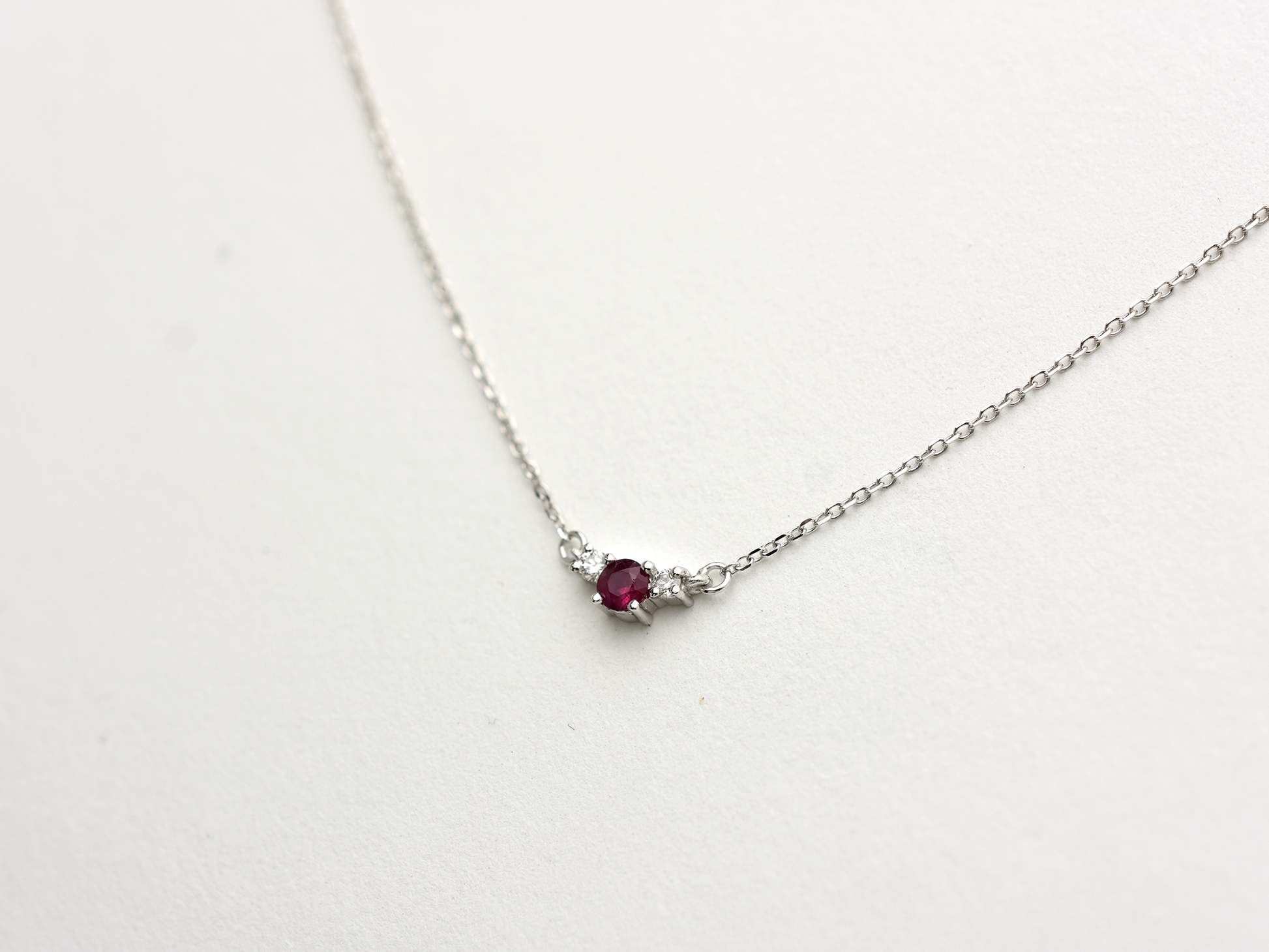 14k gold diamond and ruby necklace . past present and future design mini size pendant. the chain is a 0.8 mm cable link chain dainty and everyday look on a model