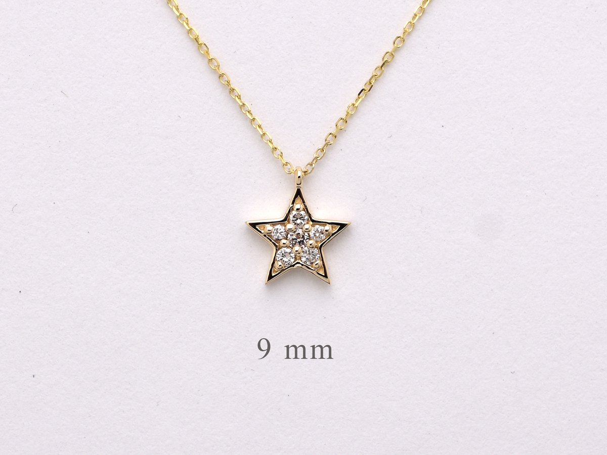 Dainty 14k gold diamond star necklace displayed on a white background.