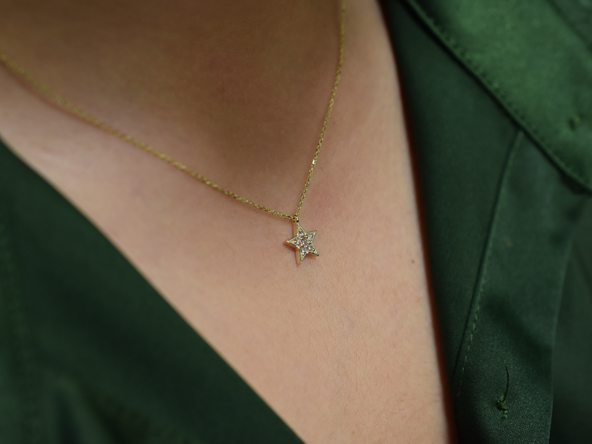 Minimalist celestial necklace with a star-shaped diamond pendant.