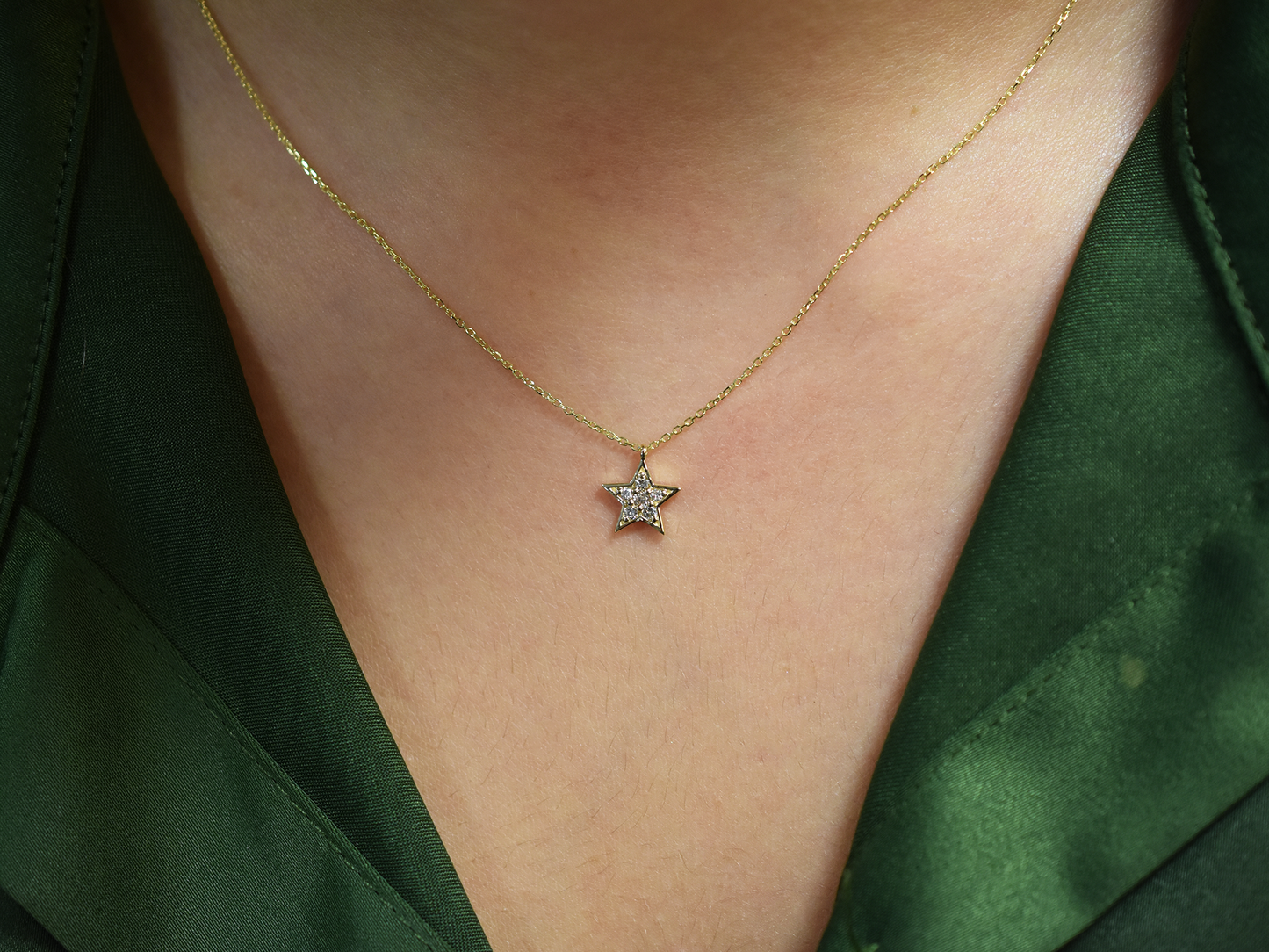 Close-up of sparkling diamond star pendant in 14k gold.
