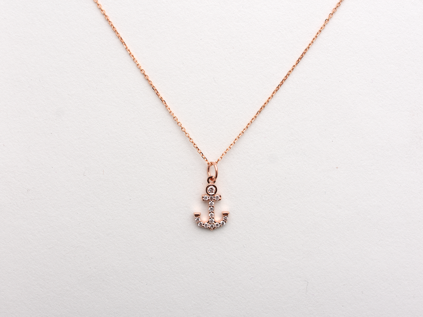 14k Gold and diamond Anchor necklace pendant with a 14k solid gold cable link chain, the diamonds are prong set and bezel set sliding on the chain displayed on a white background