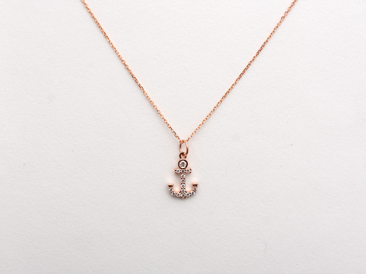 14k Gold and diamond Anchor necklace pendant with a 14k solid gold cable link chain, the diamonds are prong set and bezel set sliding on the chain displayed on a white background