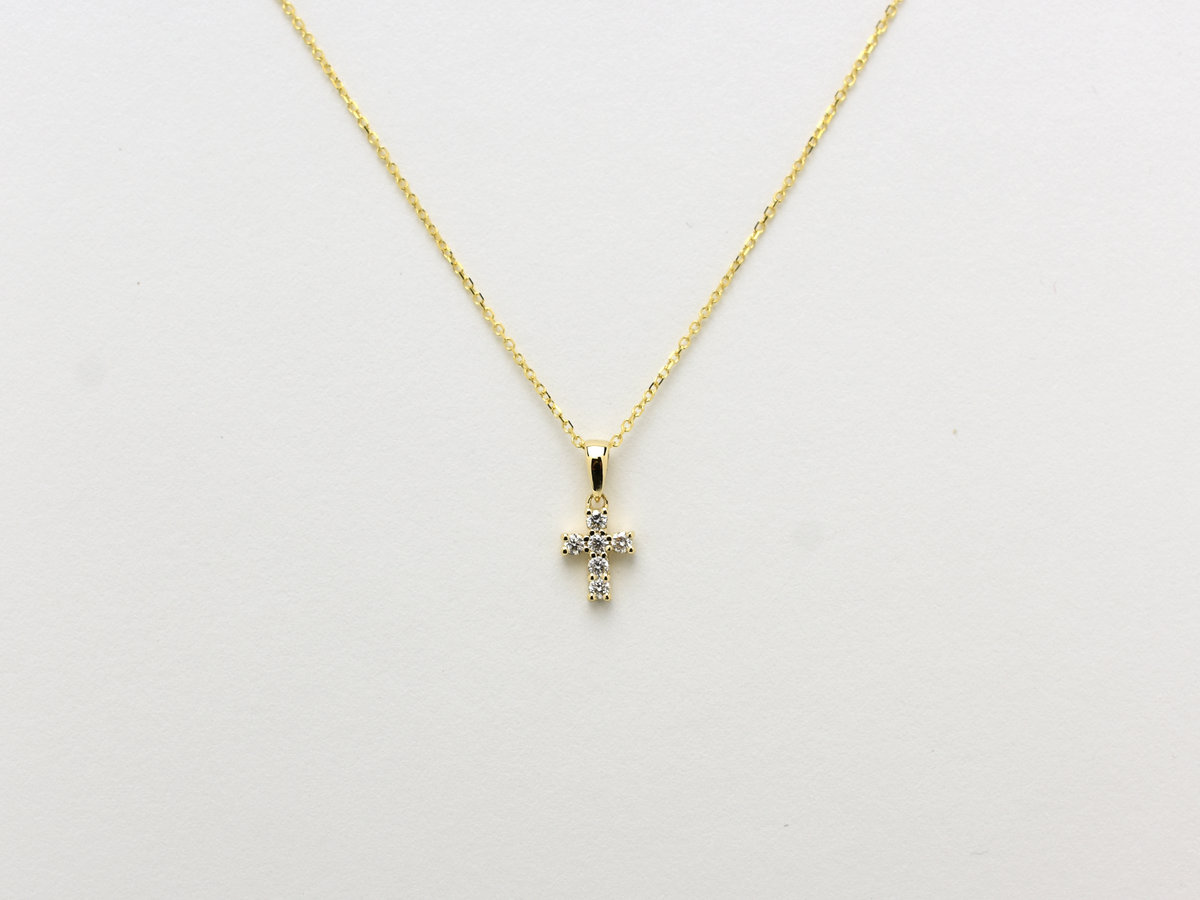 14K gold diamond cross pendant on display