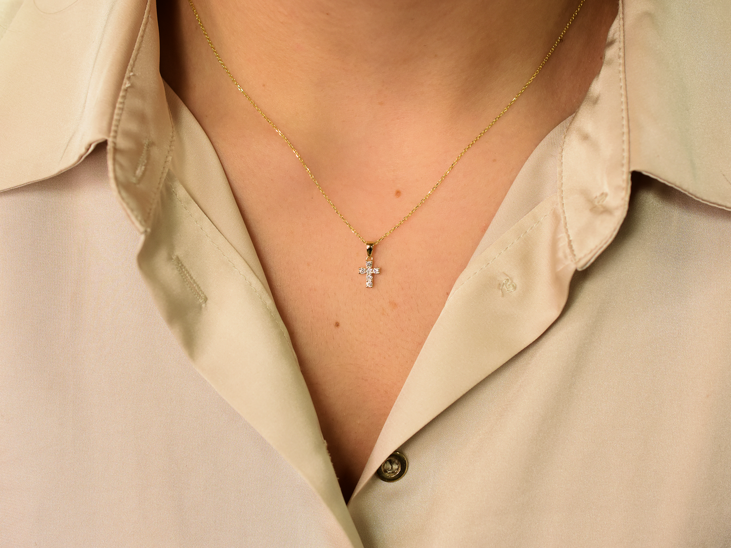 14K gold diamond cross pendant on display