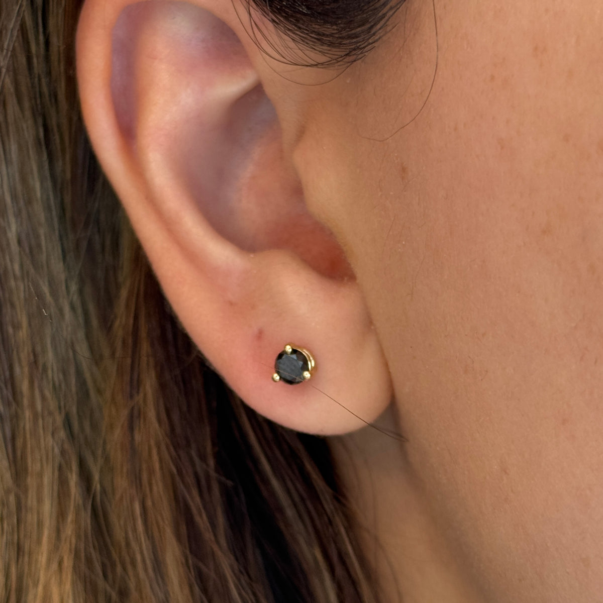 14k gold black diamond stud earrings with a 0.50 carat round shape black diamonds on a model