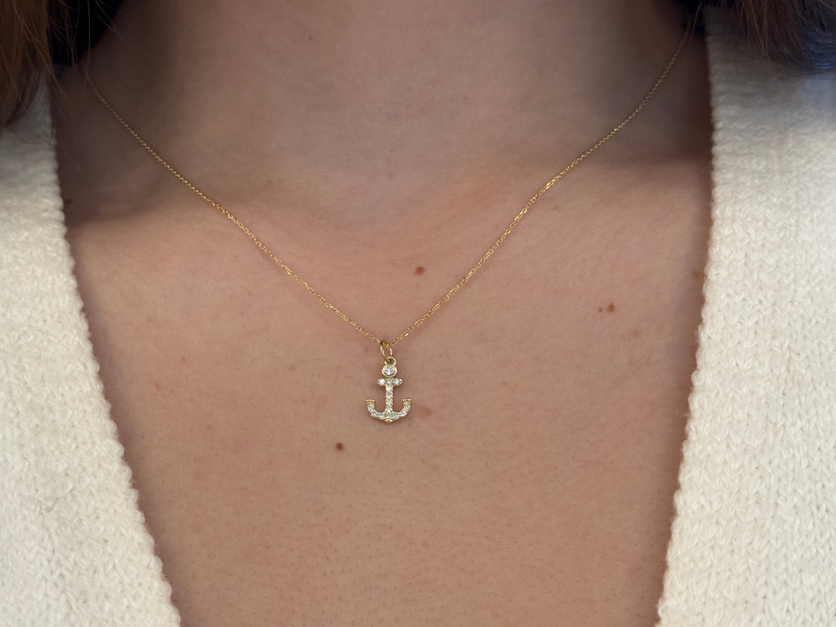 14k Gold and diamond Anchor necklace pendant with a 14k solid gold cable link chain, the diamonds are prong set and bezel set sliding on the chain displayed on a white background