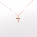 A dainty diamond cross necklace with a 14k rose gold chain.
