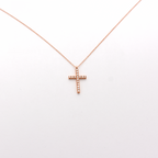 A dainty diamond cross necklace with a 14k rose gold chain.