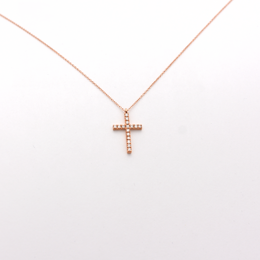 A dainty diamond cross necklace with a 14k rose gold chain.