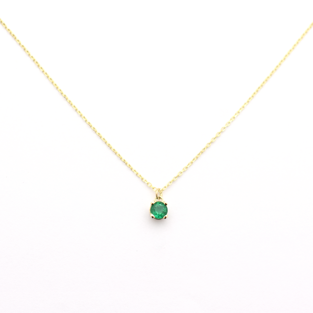 A 14k gold necklace with a single emerald stone pendant.