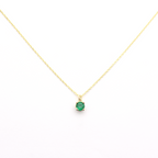 A 14k gold necklace with a single emerald stone pendant.