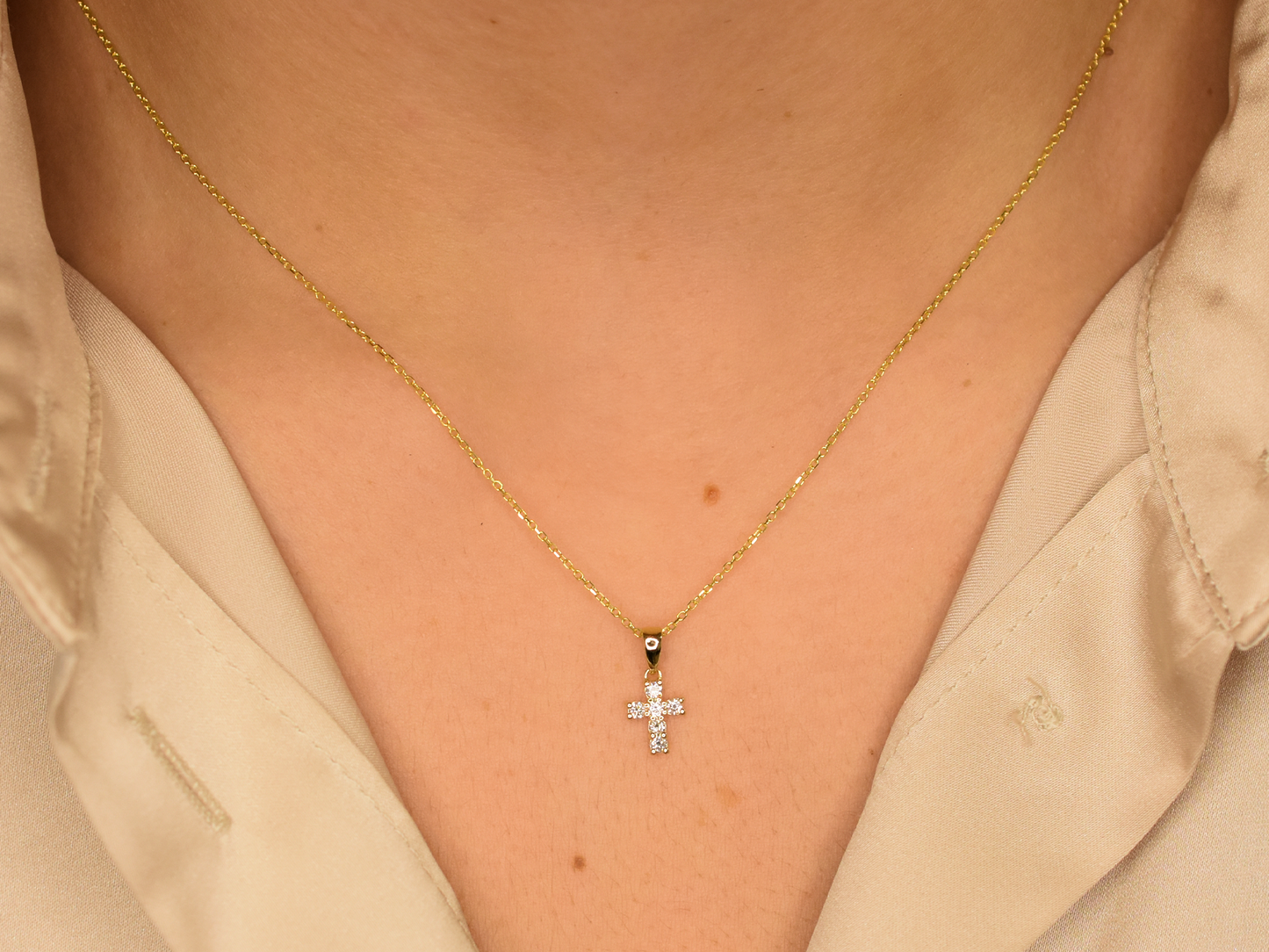 14K gold diamond cross pendant on display