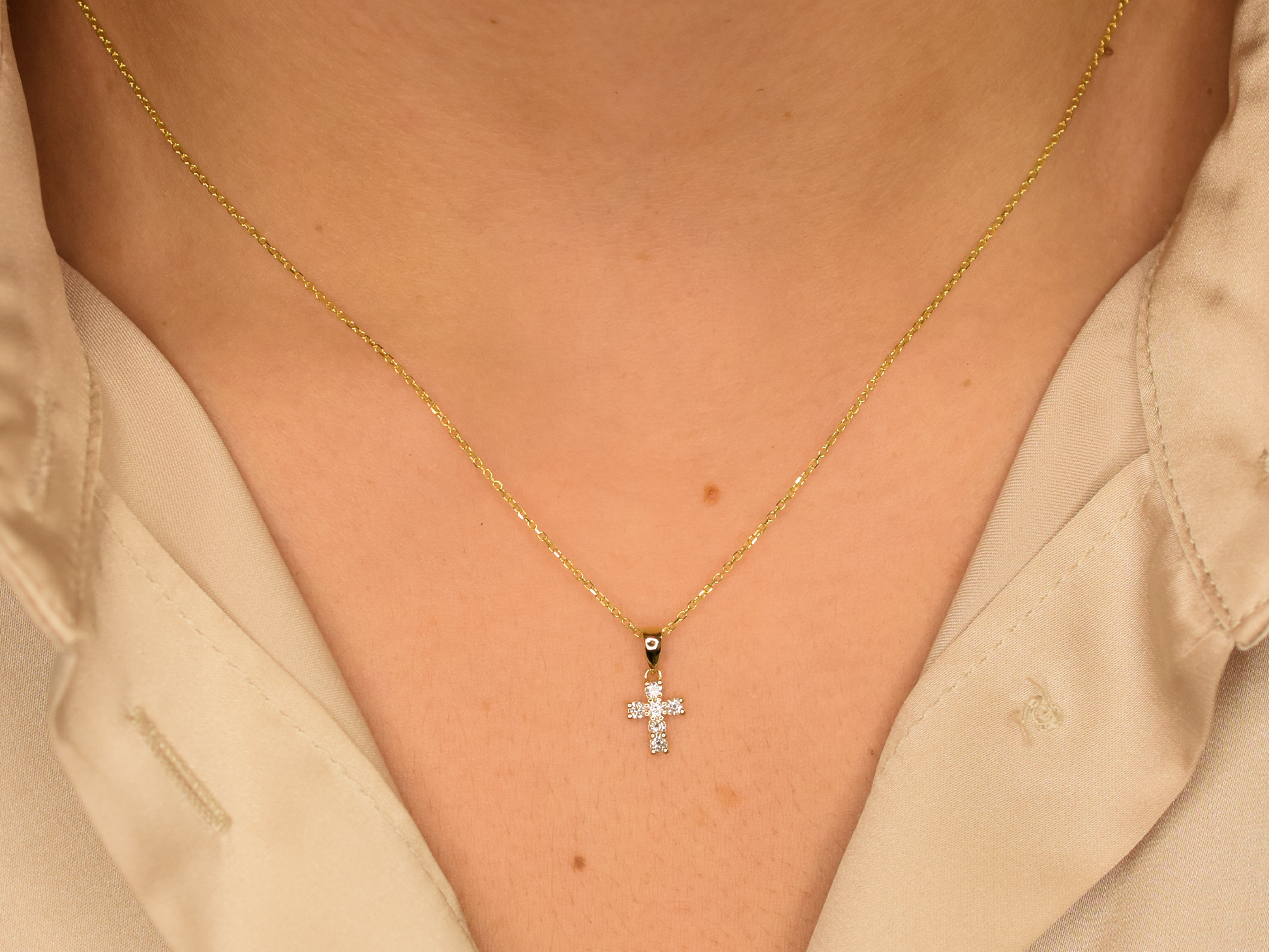 14K gold diamond cross pendant on display