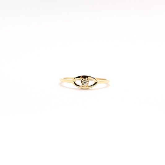 A 14K yellow gold ring featuring a round diamond set in a white gold band, known as the 'Diamond Evil Eye'.