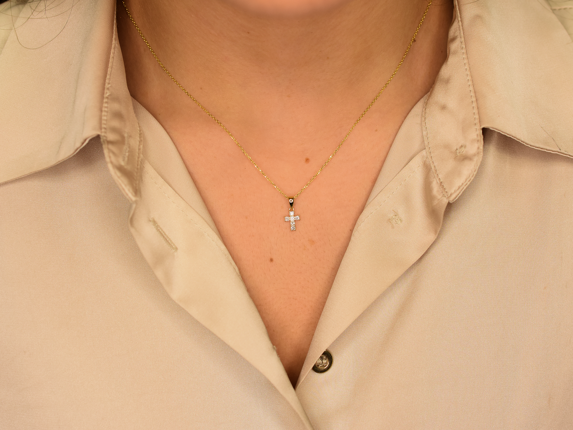 14K gold diamond cross pendant on display