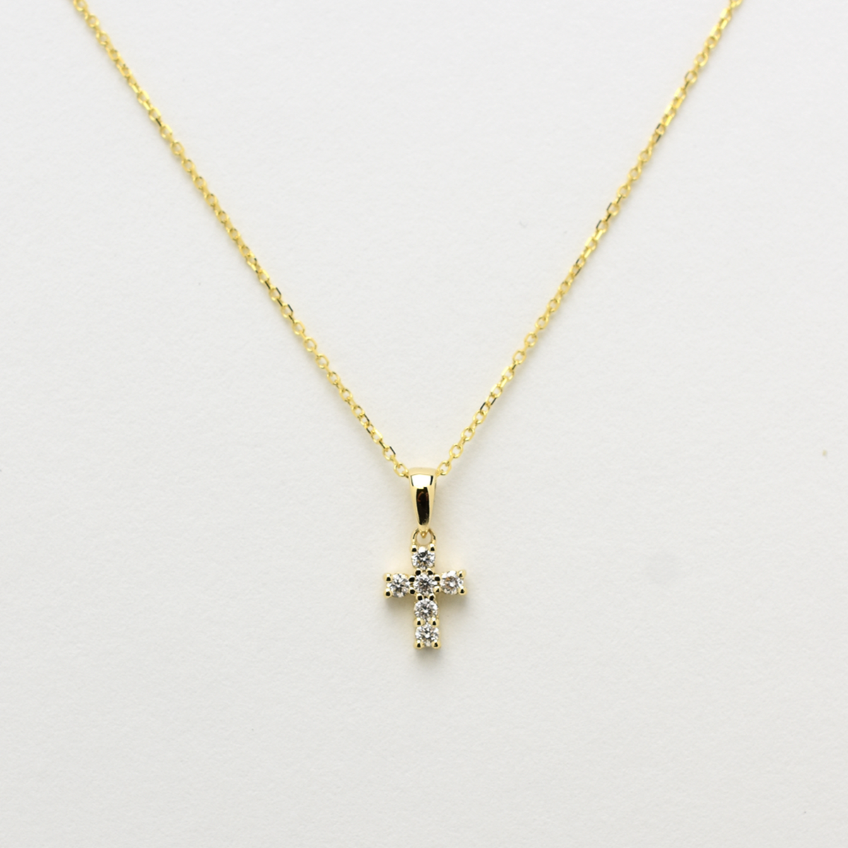 14K gold diamond cross pendant on display