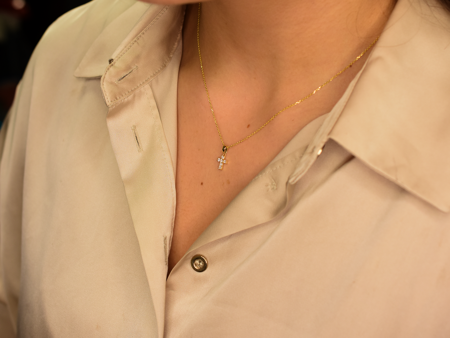 14K gold diamond cross pendant on display