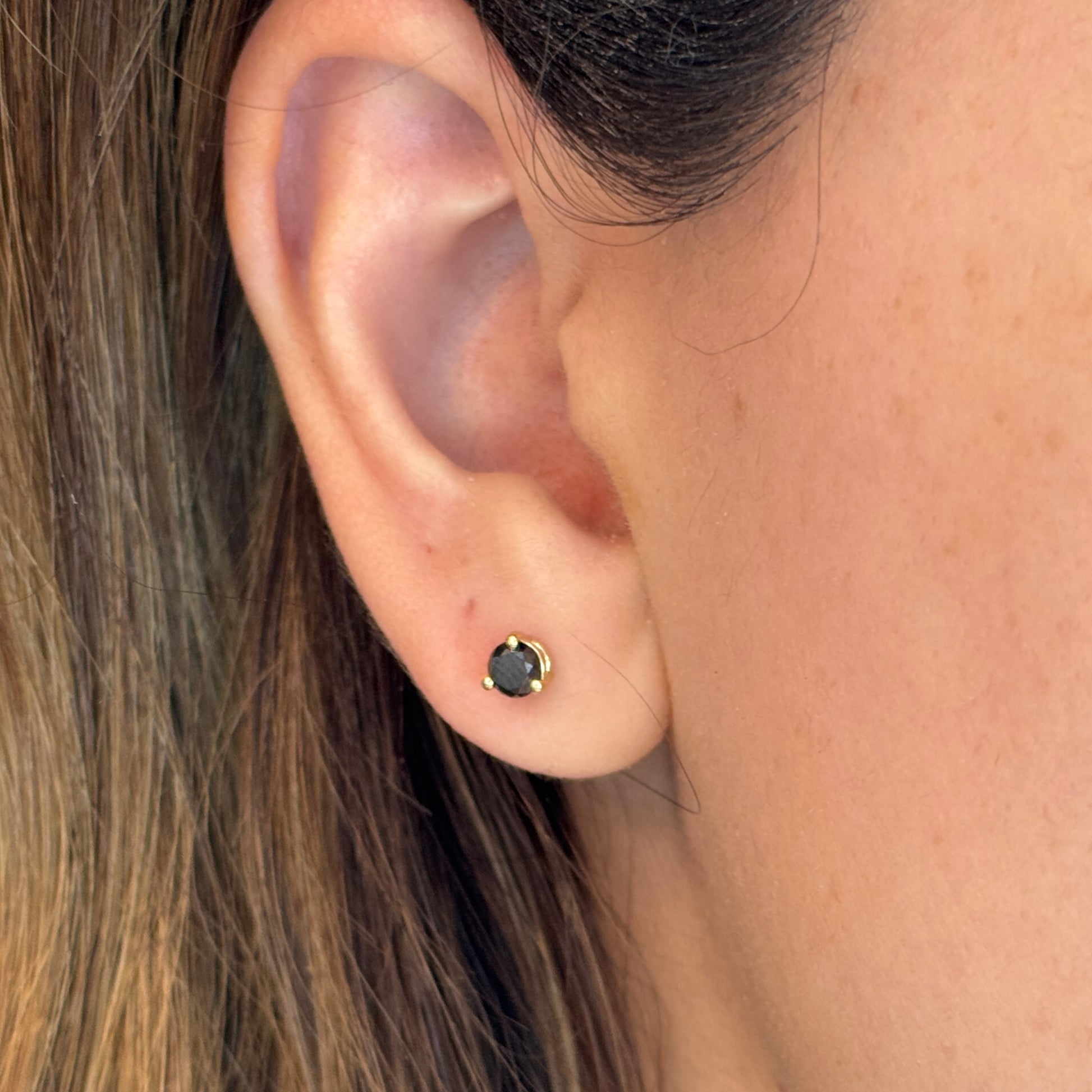 14k gold black diamond stud earrings with a 0.50 carat round shape black diamonds  on an ear