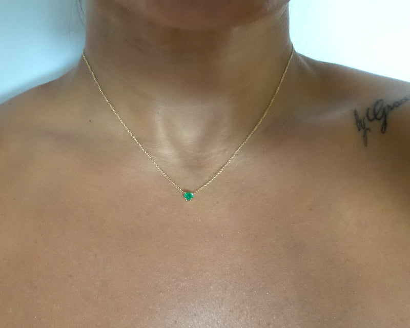 14k gold natural round shaped emerald set in a 4 prong setting with a delicate chain floating delicate look