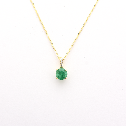 A 14k gold emerald diamond necklace with a single emerald pendant on a chain.