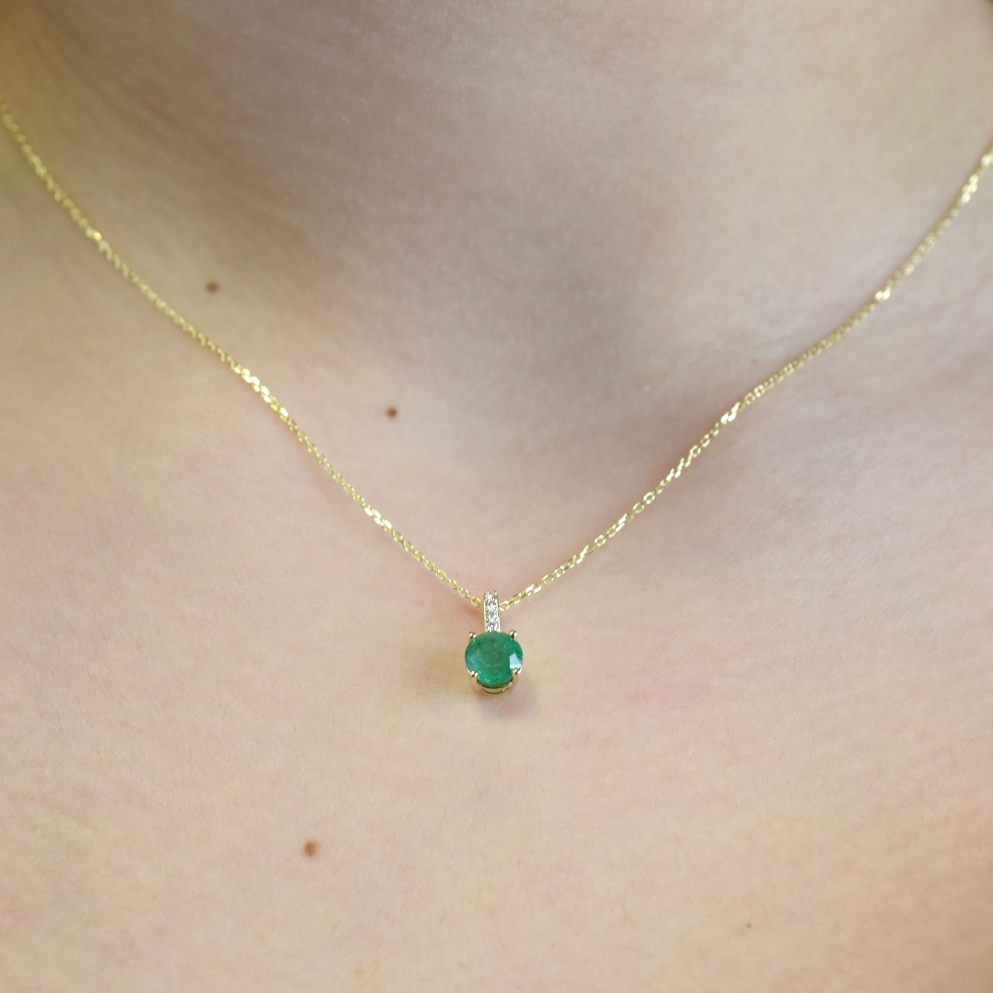 14k yellow gold necklace with a natural emerald and diamond accents