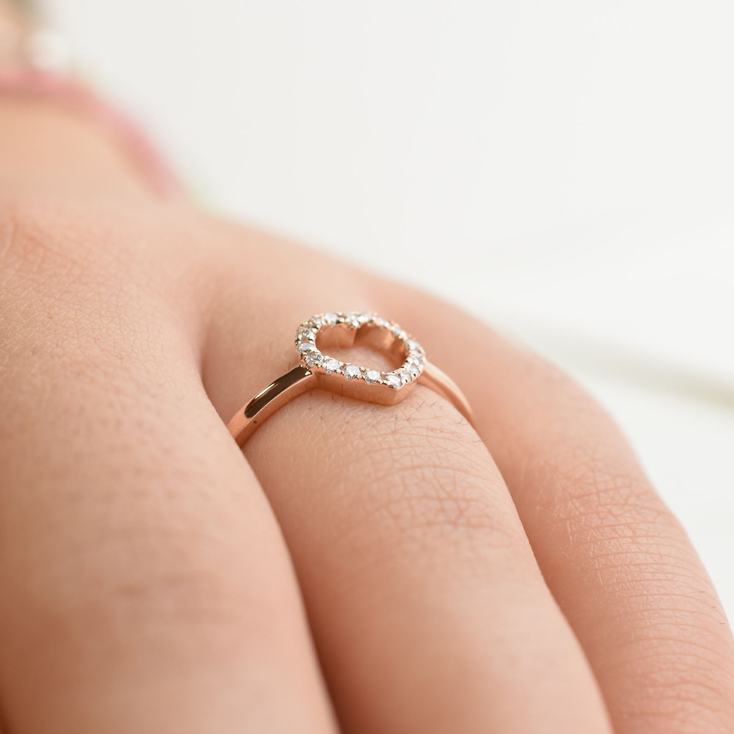 A 14k yellow gold diamond heart ring with a small heart-shaped diamond in the center, set on a plain band.