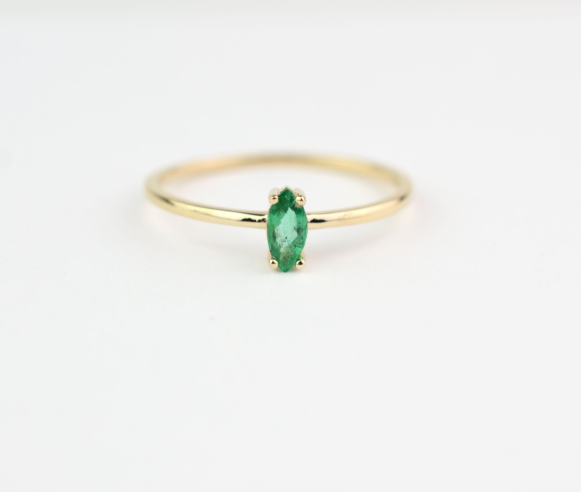 14k gold marquise shaped natural emerald set in a 4 prong setting 