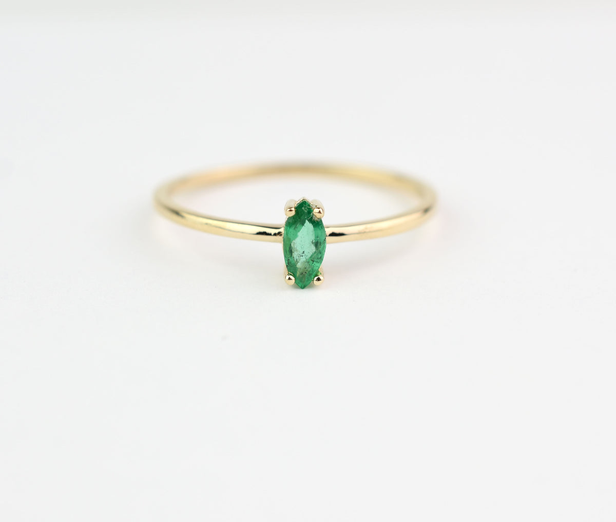 14k gold marquise shaped natural emerald set in a 4 prong setting 
